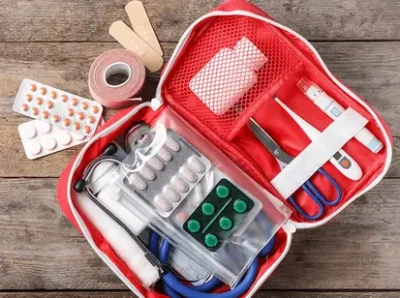 An emergency first aid kit placed on a wooden table, ready for use in case of medical emergencies.